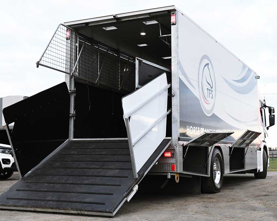 Horse transport truck with back doors open and loading ramp down